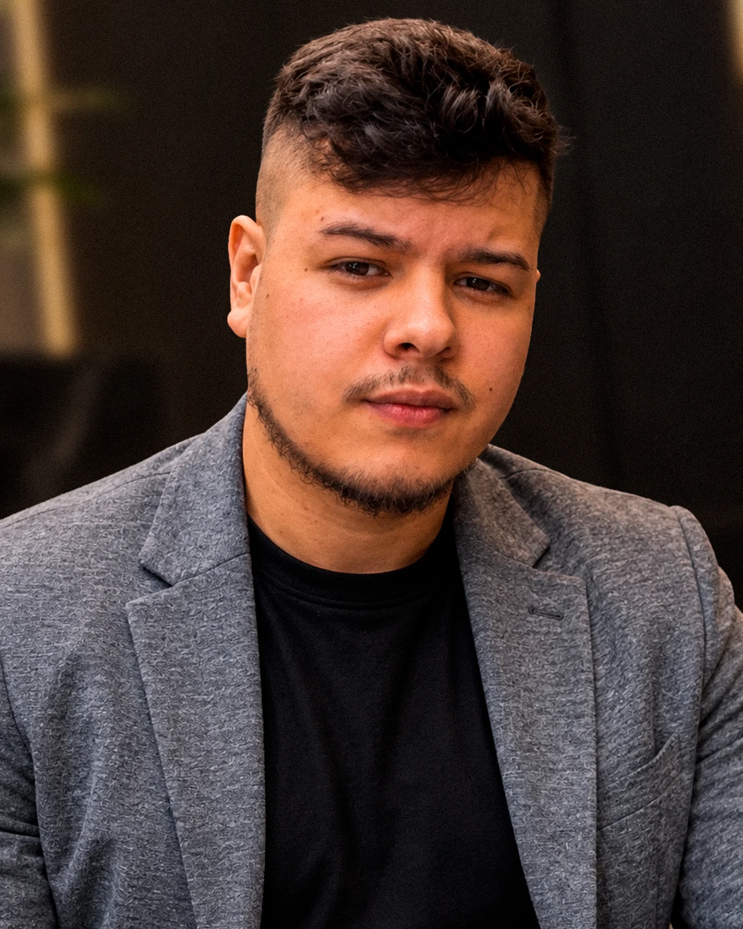 Retrato de Henrique Martins com blazer cinza